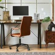 Creative composition of modern masculine home office workspace interior with black industrial desk, brown leather armchair, pc and stylish personal accessories