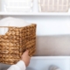 Woman organizing clothes on shelves in white opened wardrobe